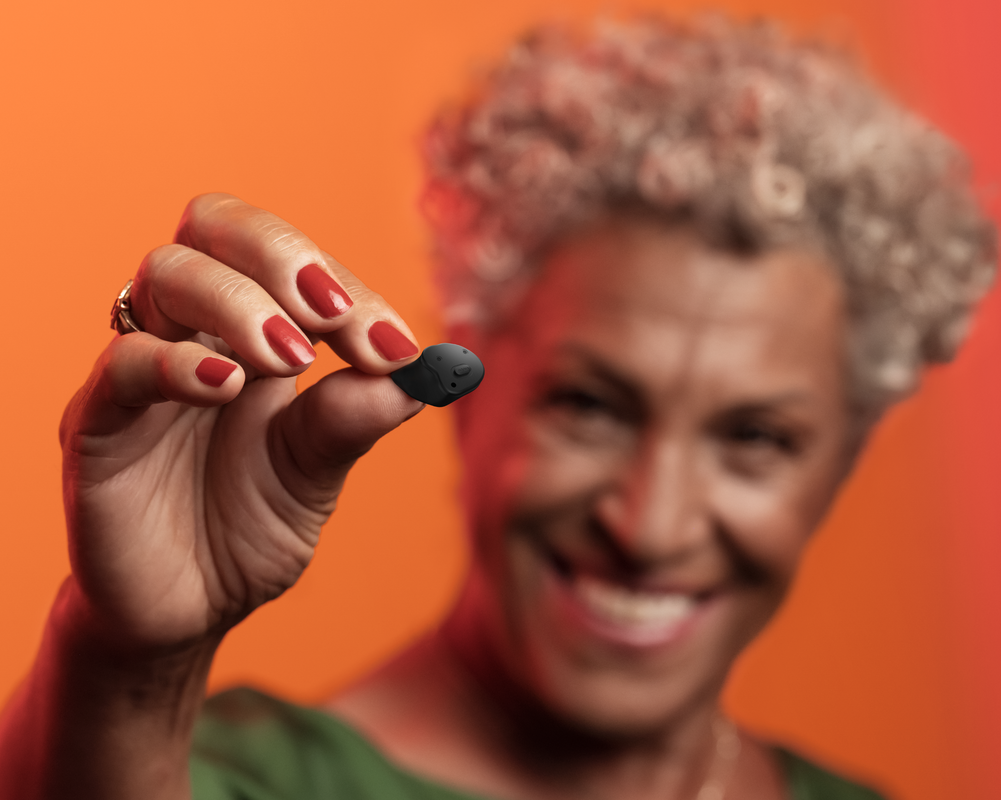 woman showing signia insio charge and go ax hearing aids