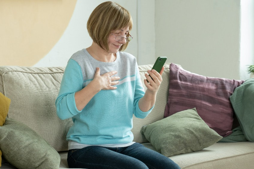 woman using her hearing aids with smartphone
